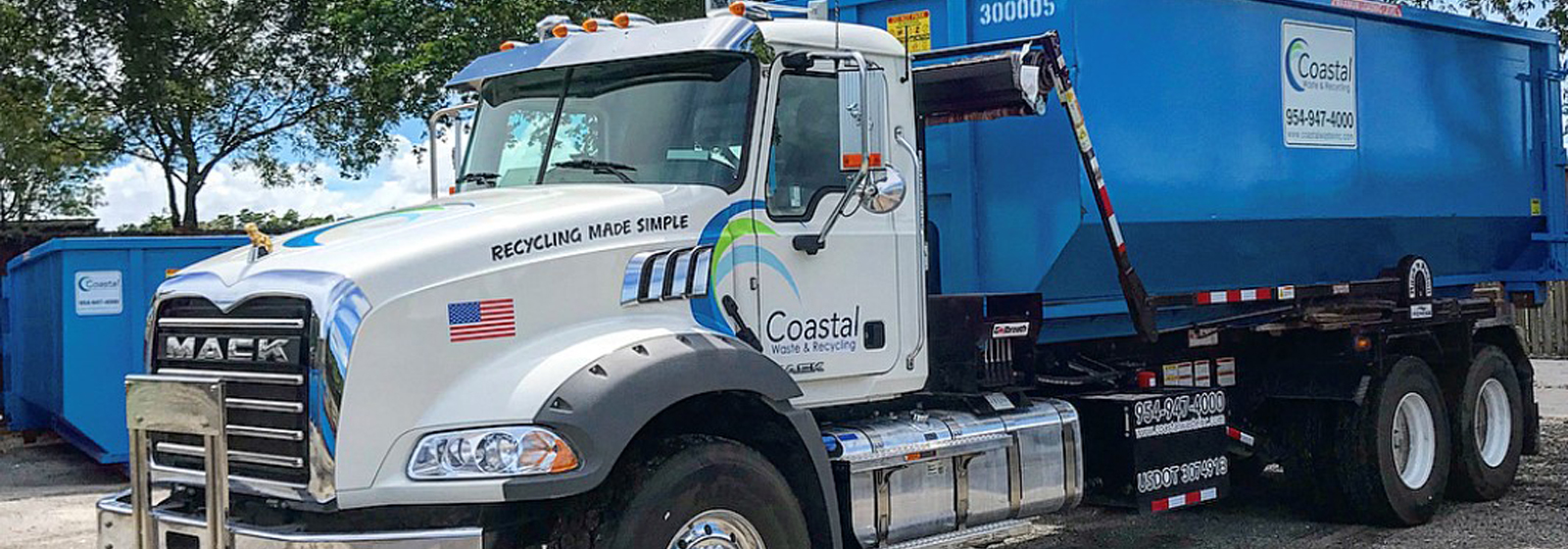 Truck carrying dumpster in Coastal Waste's Yard in Pompano Beach, FL